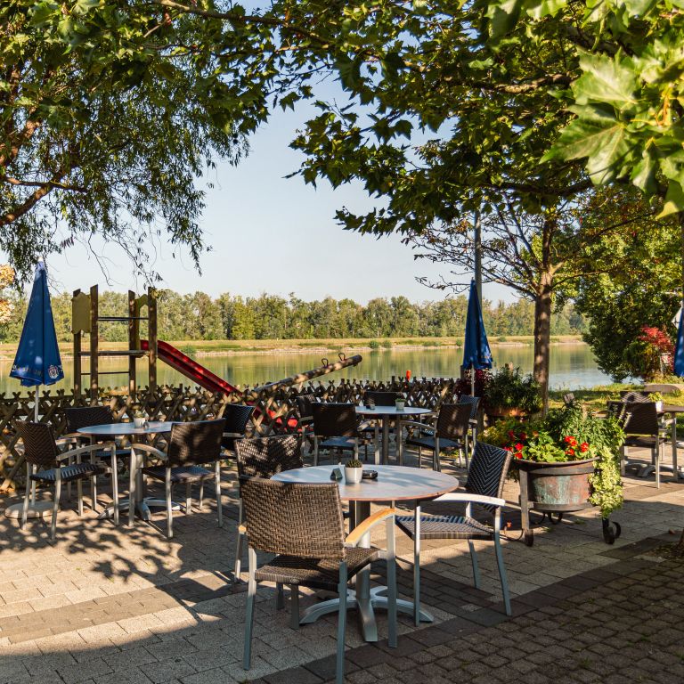 Außenbereich mit Tischen und Kinderspielplatz